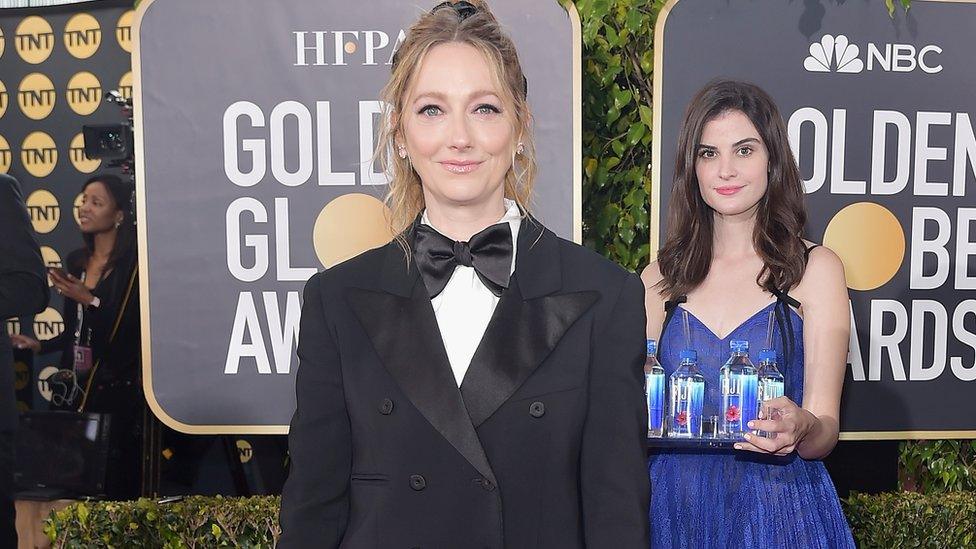 Model posing behind Judy Greer