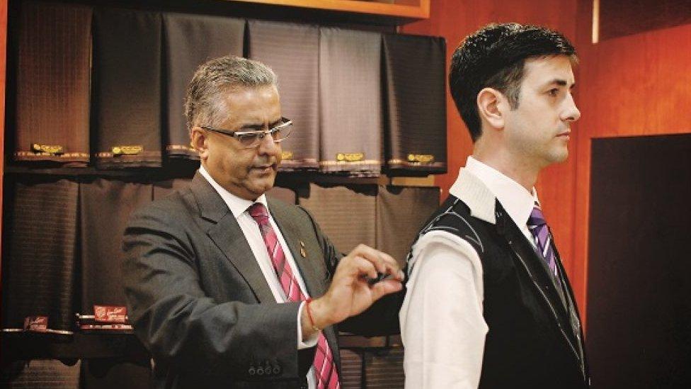 Raja Daswani measuring customer for suit