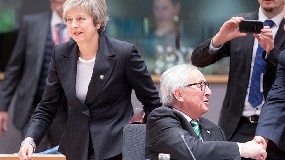 Theresa May standing beside President of the European Commission Jean-Claude Juncker at a meeting in Brussels in December