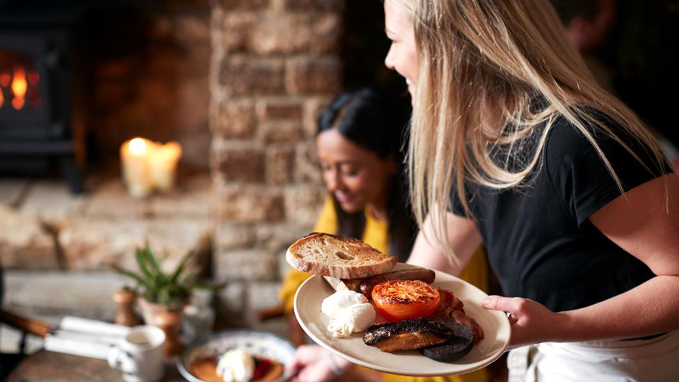 Stock image of a waitress serving food