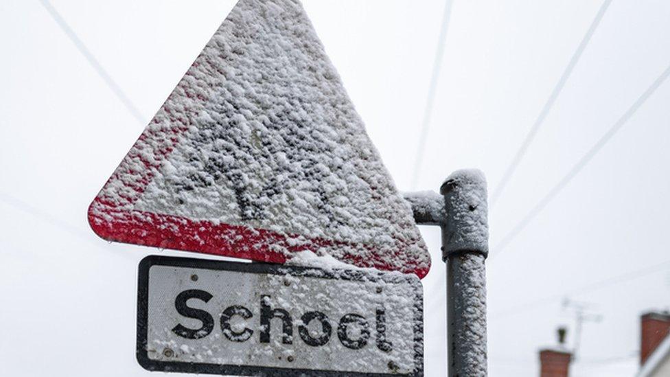 school sign covered in snow