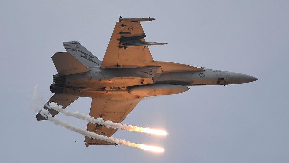 A Royal Australian Air Force (RAAF) F/A-18F Super Hornet drops two flares as it performs during the T150 Defence Force Air Show on October 15, 2016 in Townsville, Australia.