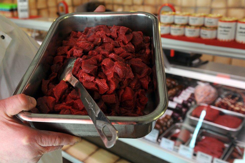 A butcher holds a tray of horsemeat on sale at his shop in Bremen, northern Germany, 14 February 2013