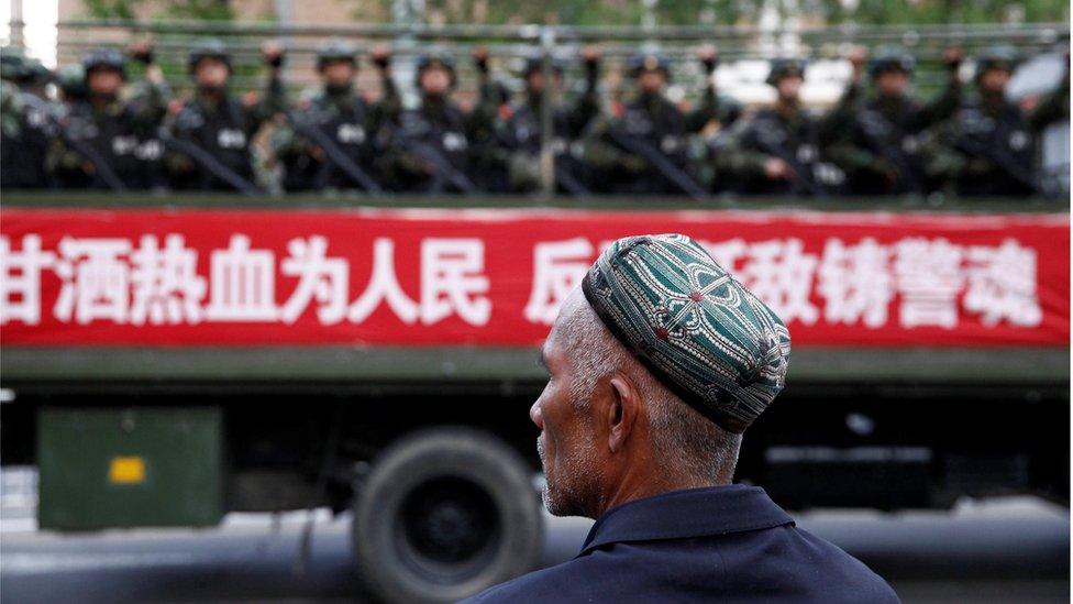 Uighur looks at military police in Xinjiang