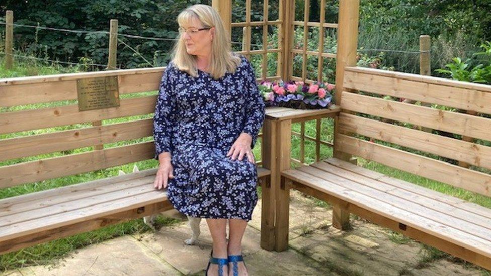 Louise Hough on the bench she had made in the garden to remember Vernon Hough