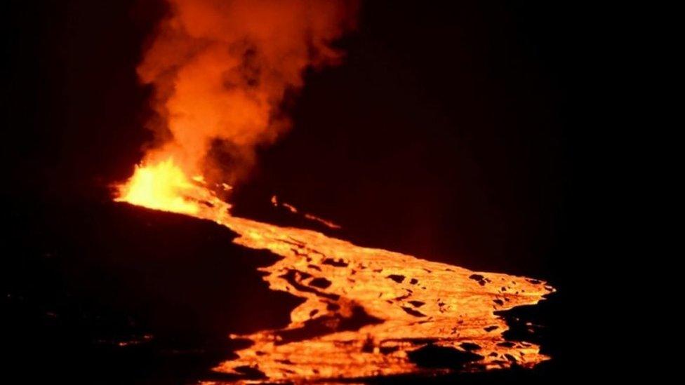 Handout picture released by the Galapagos National Park press service showing lava flowing down the Sierra Negra volcano on Isabela Island in the Galapagos Archipelago about 1000 km off the Ecuadorean coast in the Pacific Ocean, early on June 27, 2018.