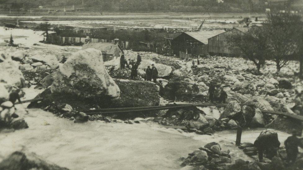 Villagers using planks to cross Dolgarrog following the dam disaster