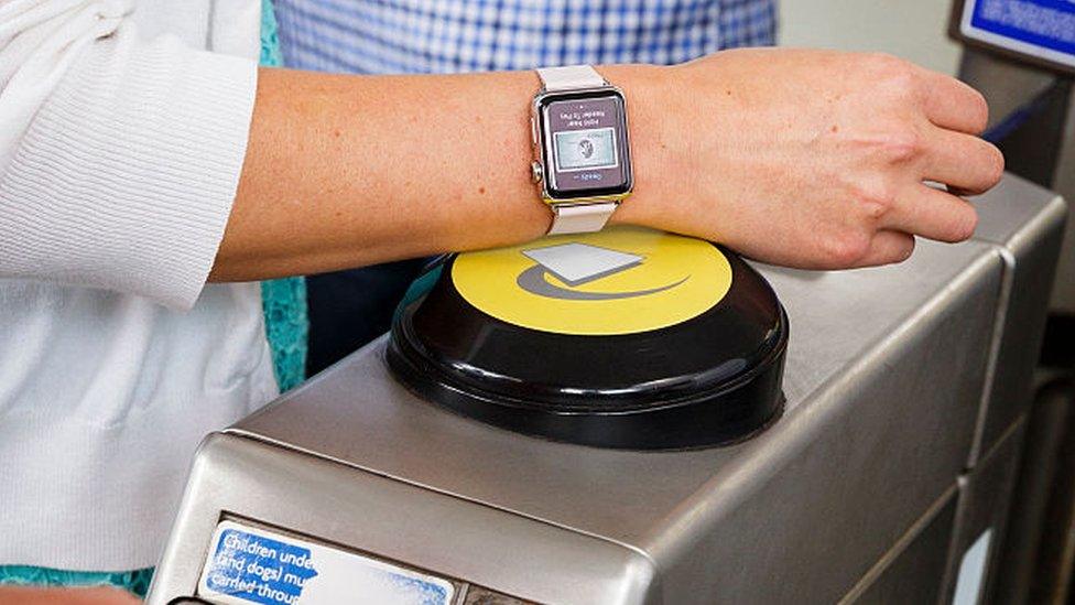 A commuter using their Apple Watch to enter the tube