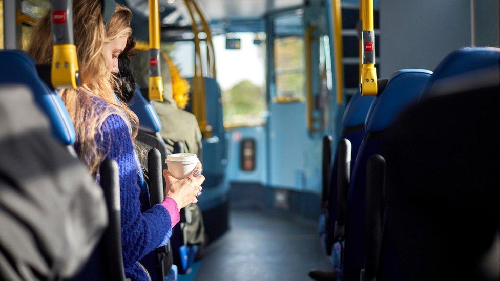 Woman drinking coffee on bus