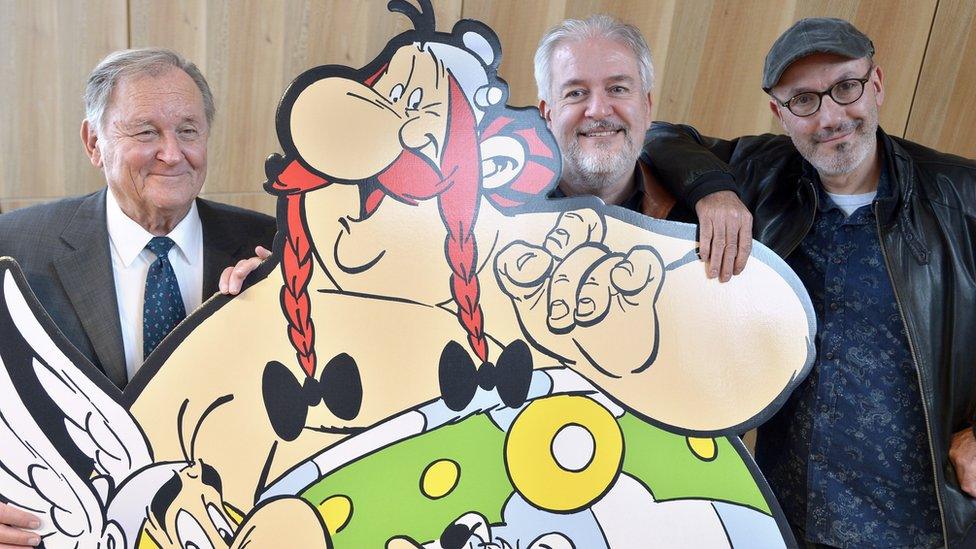 (From L) French cartoonist and author Albert Uderzo, French cartoonist Didier Conrad, and the co-author of the popular comic book Asterix with Uderzo, writer and designer Jean-Yves Ferri pose beside a cardboard cut-out of Asterix and Obelix characters during a press conference in Paris