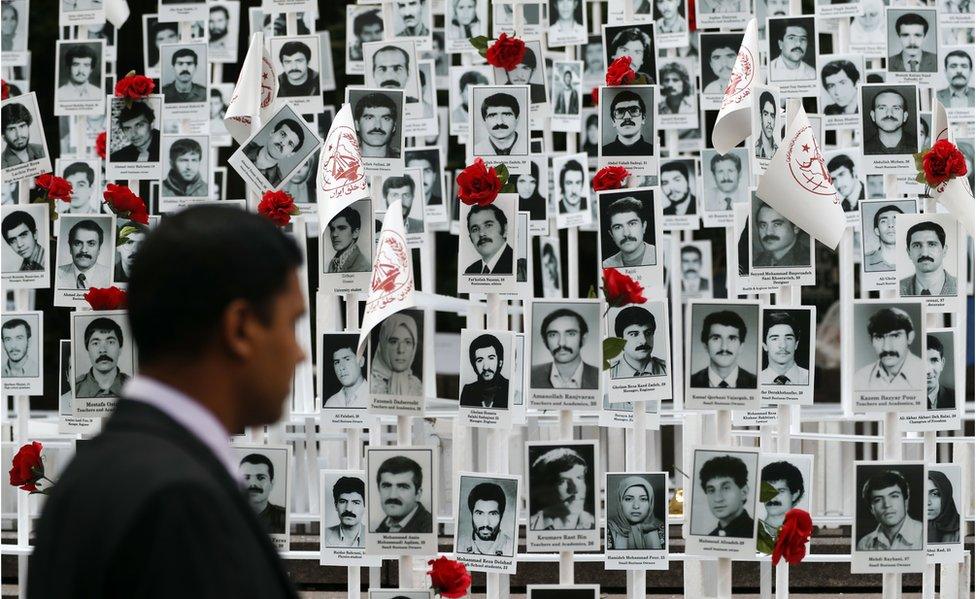 A man looks at photos of people executed in Iran during a rally outside the United Nations headquarters in New York on Tuesday, 20 September, 2016.