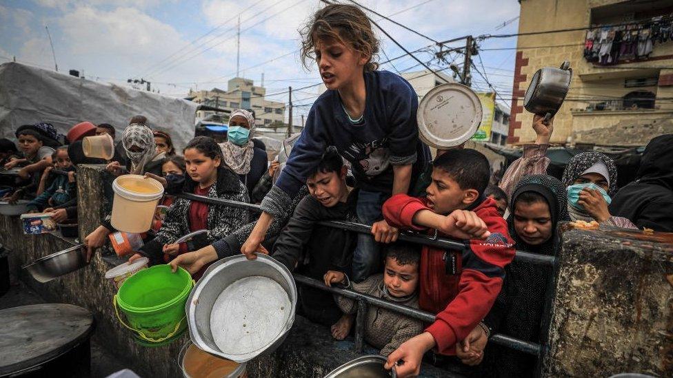 Famine looms in Gaza, Children queue to receive food at a a donation point in Rafah