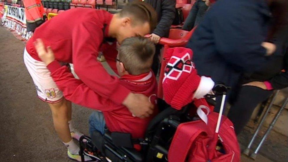 Oskar Pycroft gets a hug from Bristol City midfielder Joe Bryan