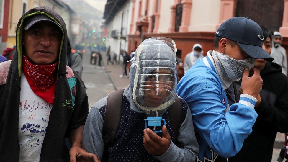 A protester uses a plastic bottle as a gas mask