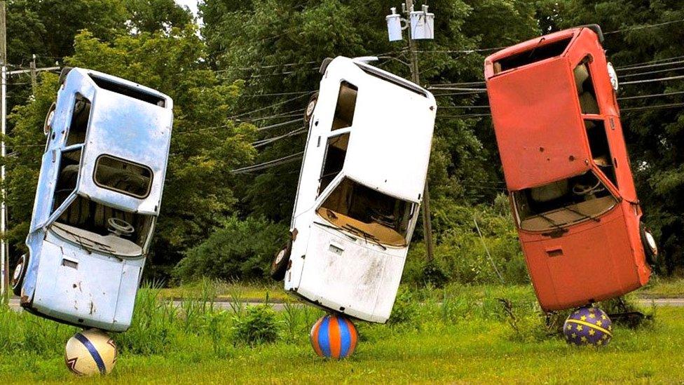 Three cars balanced to form a sculpture