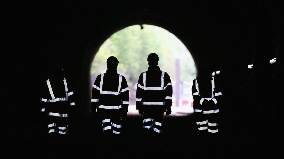 Silhouette of George Osborne and workers in a tunnel