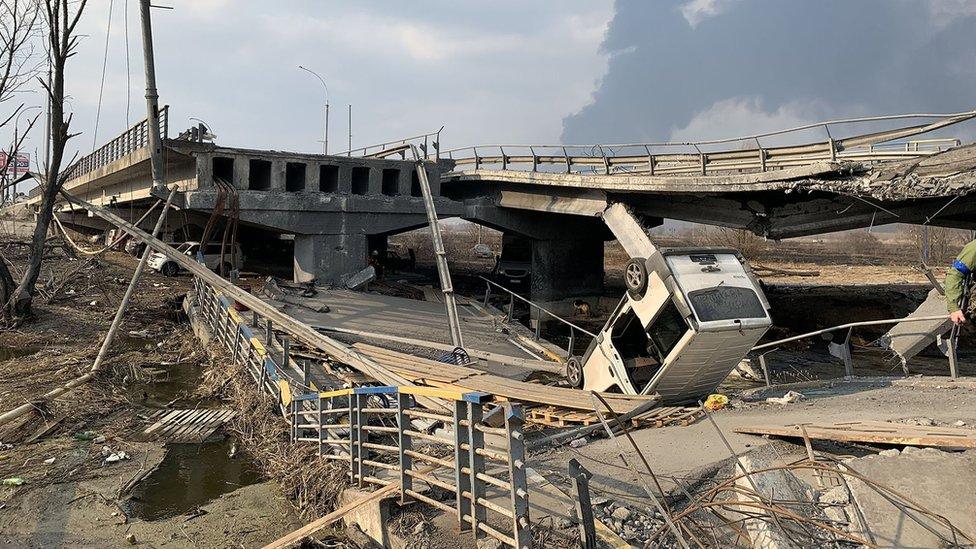 An overturned van on the destroyed bridge in Irpin