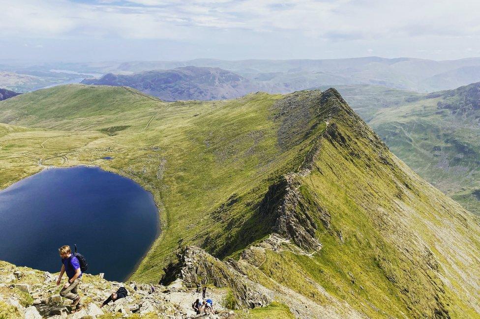 Walkers climb Striding Edge towards the top of Helvellyn