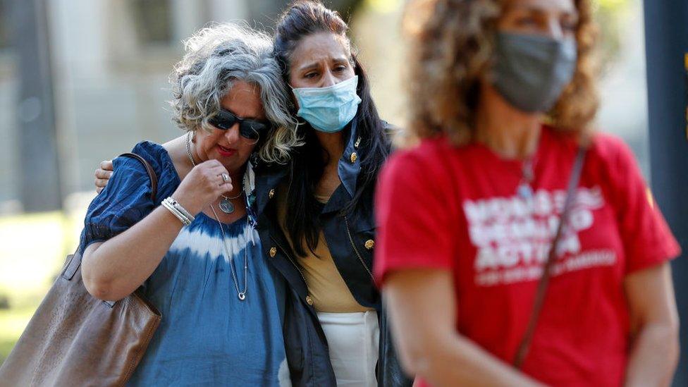 San Jose residents Jenny Niklaus (left) and Jessica Garcia-Kohl embrace comfort each other during interfaith prayer vigil in St. James park for VTA shooting victims in San Jose on Wednesday, May 26, 2021.