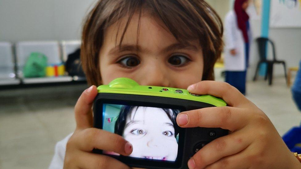 Refugee child taking a selfie