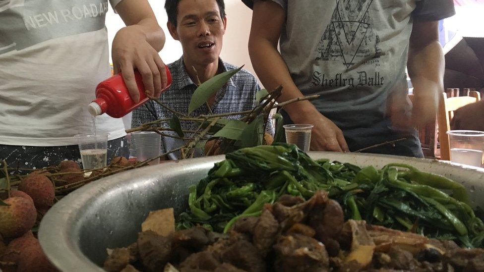 A man sitting in front of a stew at the Yulin festival