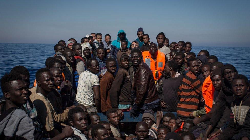 Migrants afloat in the Mediterranean wait to be rescued by Italian authorities.