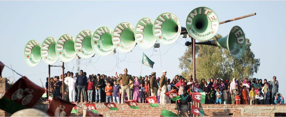 Villagers watch Akhilesh Yadav's rally from the roof of a nearby home