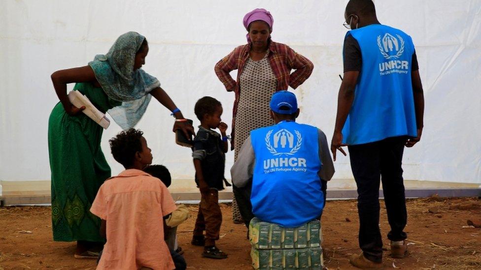 Humanitarian workers from UNHCR talk to Ethiopian refugees