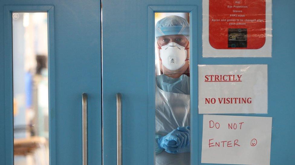 An infection control nurse looks out from a Covid-19 recovery ward at Craigavon Area Hospital in May 2020