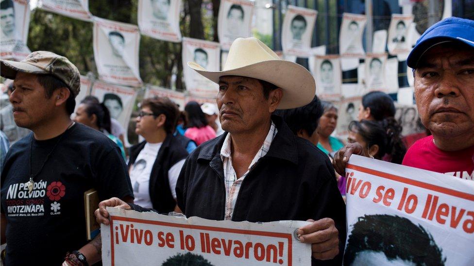 Relatives of 43 missing students from the Isidro Burgos rural teachers" college hold pictures of their missing loved ones after meeting with Attorney General Arely Gomez Gonzalez in Mexico City, Thursday, March 17, 2016.