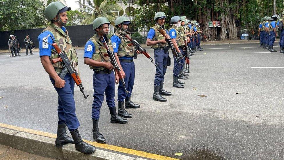 Sri Lanka security forces stand in a line armed with rifles