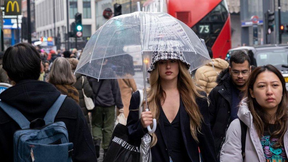 Woman holding an umbrella on Oxford Street