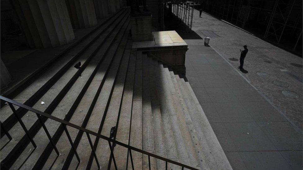 A person on the empty streets in front of the New York Stock Exchange