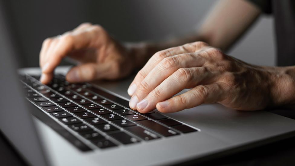 Stock image of hands typing on a laptop