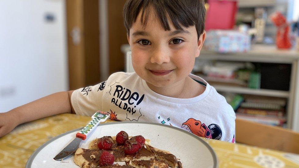 Quinten eating a plate of pancakes