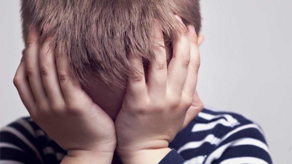 Boy with head in hands