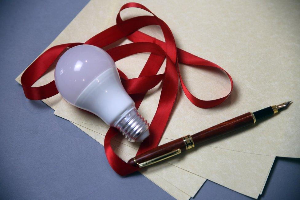 A light bulb, ribbon and a pen