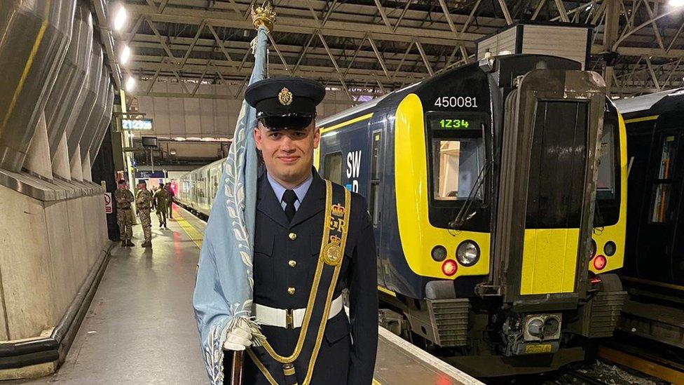 An RAF recruit carrying a flag