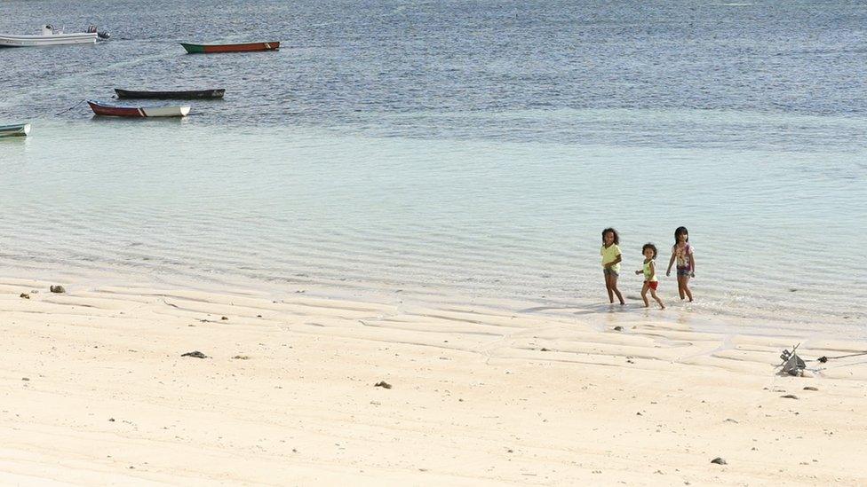 Children play on a beach in Rote