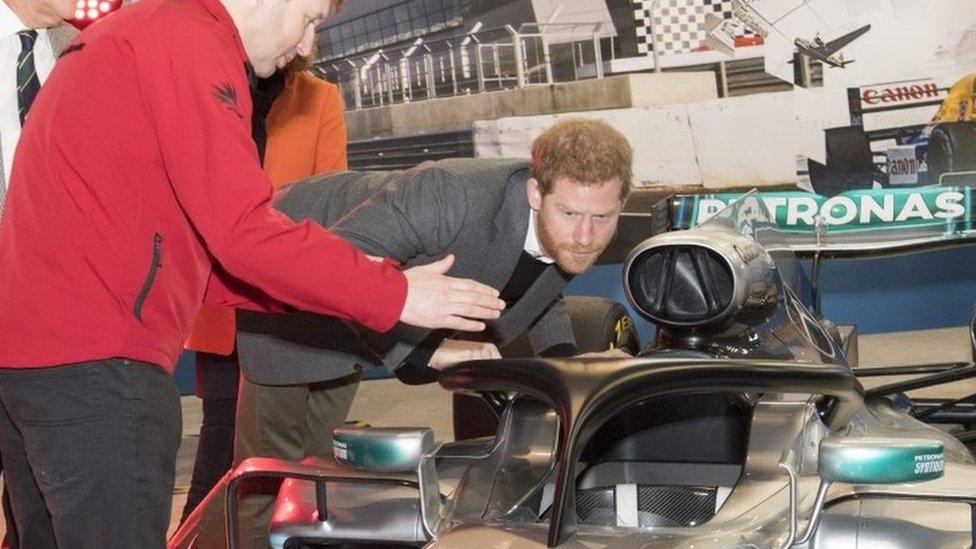 Prince Harry, studies the "Halo" on Lewis Hamilton"s Mercedes, a new safety addition to Formula 1 cars this year, during a visit to the Silverstone Circuit in Northamptonshire