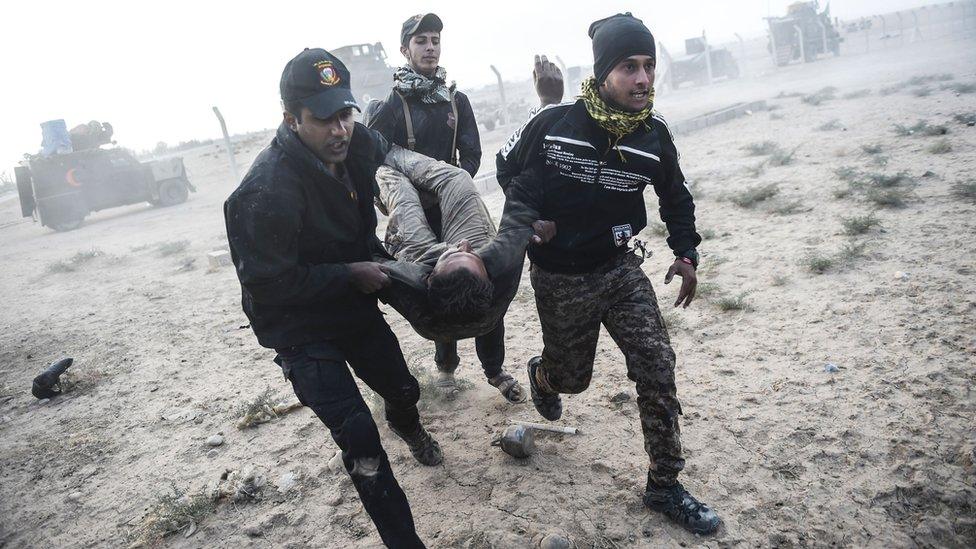 Iraqi Counter Terrorism Service (CTS) personnel carry an injured comrade during clashes with Islamic State (IS) on the eastern edges of Mosul, 31 October 2016