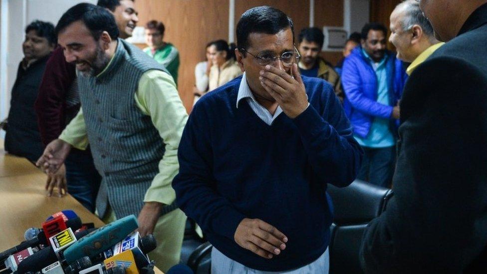 Delhi Chief Minister Arvind Kejriwal (C) coughs ahead of addressing the media at a press conference in New Delhi on December 24, 2015