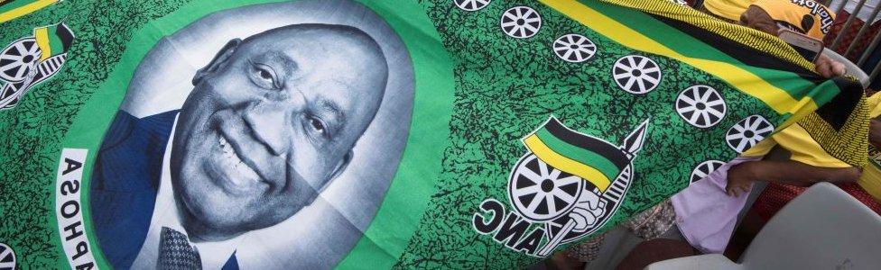 A cloth being held by African National Congress (ANC) supporters showing the face of South African President and ANC President Cyril Ramaphosa t