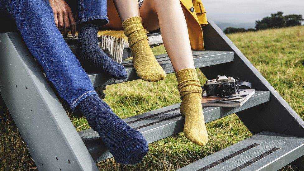 Couple wearing socks sitting on a jeep