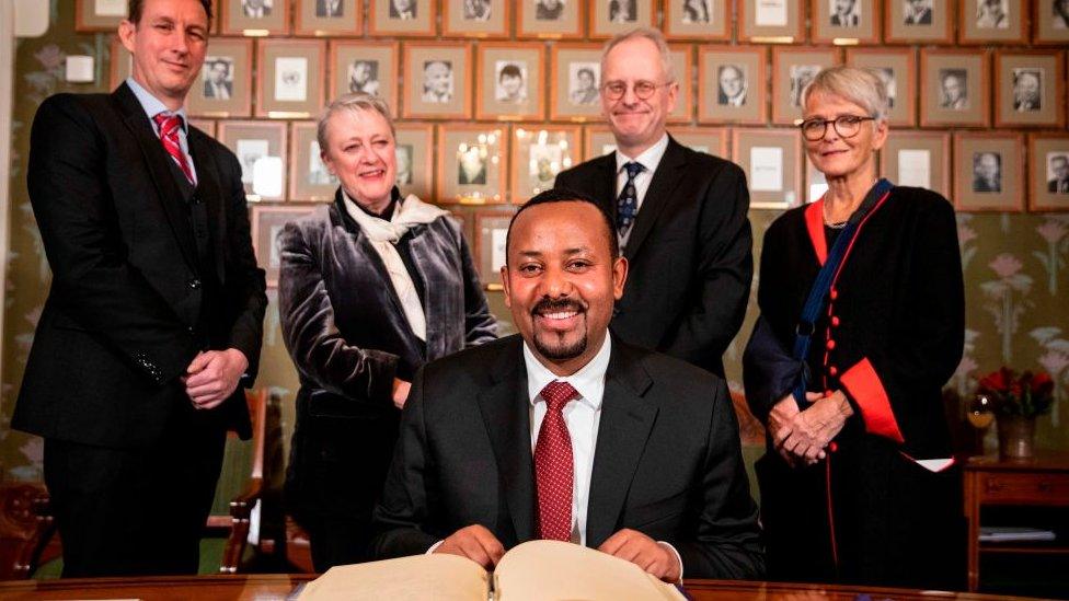 Ethiopia's Prime Minister and this year's Nobel Peace Prize Laureate Abiy Ahmed Ali (C) signs the Nobel Protocol at his arrival in Oslo