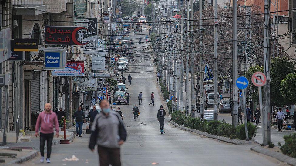 Palestinians walk down a street in Gaza City in April before the recent fighting broke out