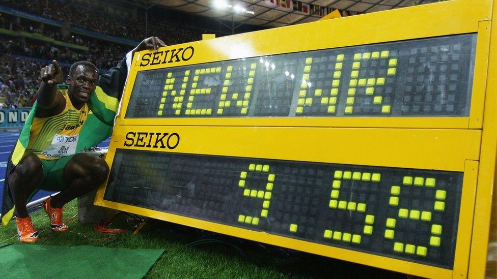 Usain Bolt poses in front of the clock