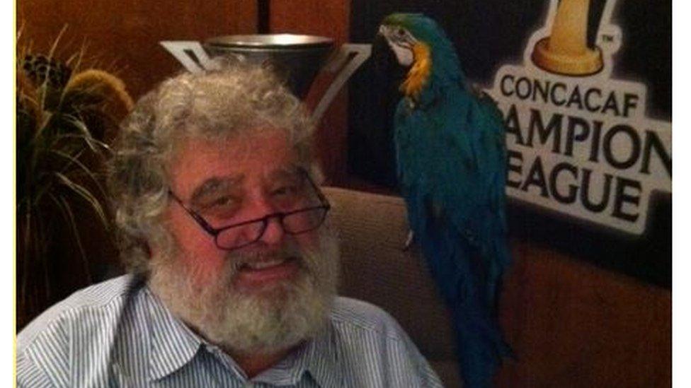 Chuck Blazer sat with pet parrot on his shoulder