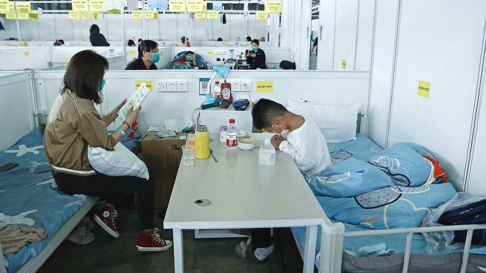 A child accompanied by her mother studies while receiving treatment in the quarantine zone at the Shanghai New International Expo Center on April 10, 2022