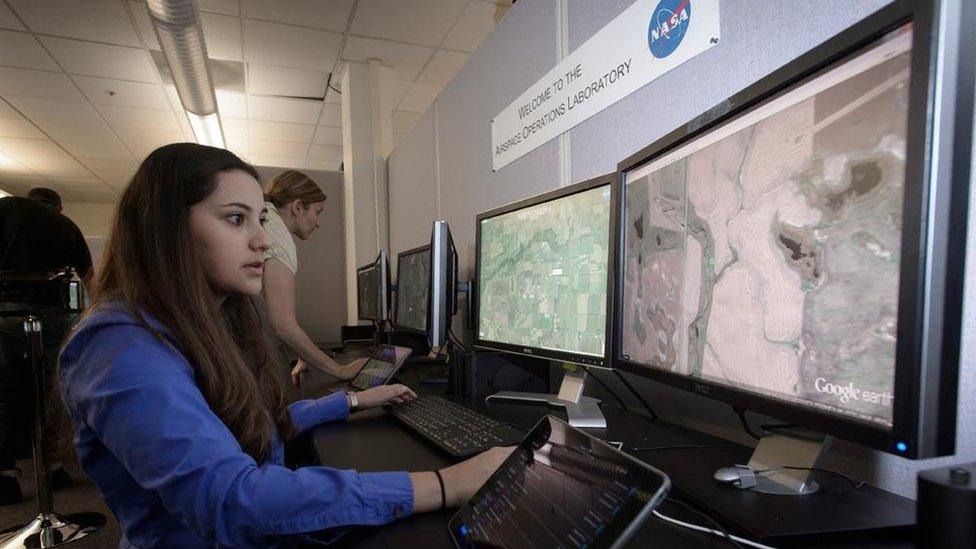 Woman monitoring big computer screens